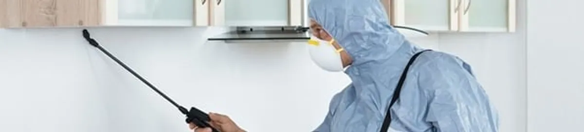 Termite treatment technician applying indoor pest control spray in Orange, CA