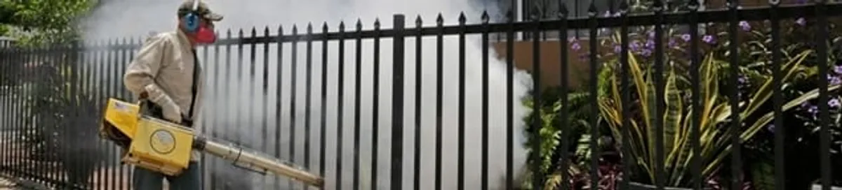 Mosquito control technician fogging a yard perimeter for mosquito reduction in Orange, CA
